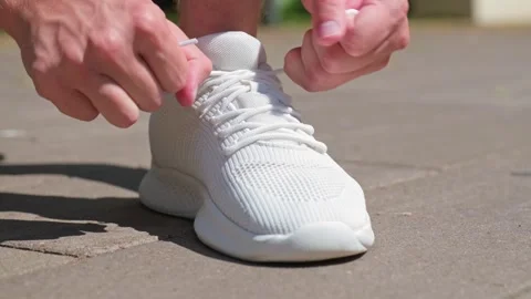 Close up shot of a man tying white sport shoes before a morning run. Tying .. Stock-Footage 339861293