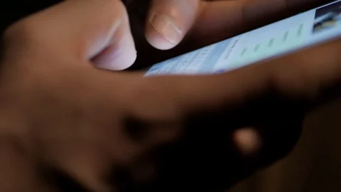Close up shot of a man typing a message on his smartphone home, at night, 4K Stock Footage