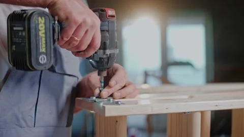 Close shot of man using electrical screwdriver working with wood construction Video stock 170502629