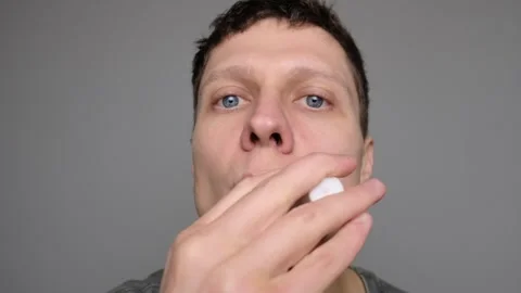 A close-up shot of a man using lip balm, focusing on lips and facial details wit Stock Footage 296883153