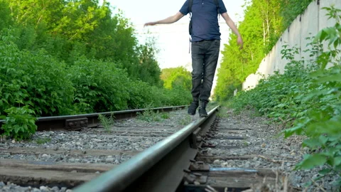 Close-up shot of a man walking on the rails. Walk along the railroad tracks. Old Video stock 154575710