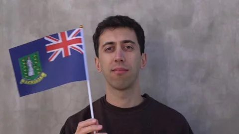 Close up shot of a man waving British Virgin Islander flag in slow motion Stock Footage 337890897