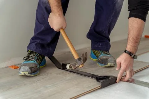 Close up shot of a man worker fitting laminate flooring Stock Photos