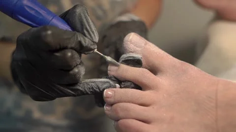 Close-up shot of a manicurist using electric file for pedicure procedure Stock Footage 336179158