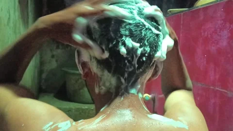 A close-up shot of a man's back and head while shampooing his hair. Stock Footage 321931358