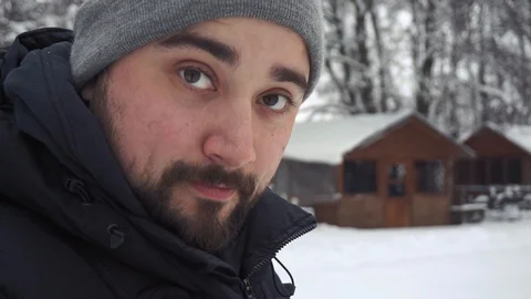 Close shot of man's bearded face in the winter park. He is looking on his camera Stock Footage 101119325