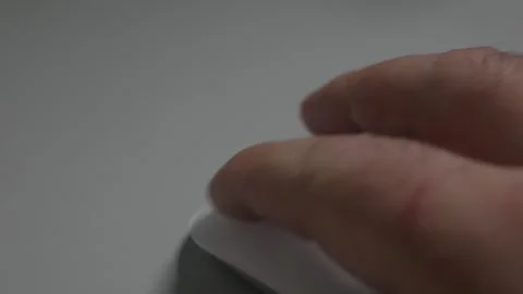 A close-up shot of a man's hand clicking and moving a sleek white wireless .. Stock Footage 321936409
