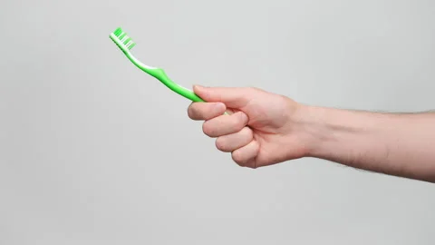 Close up shot of a man's hand holding a toothbrush, copy space on the left. 4 Stock Footage 238546429