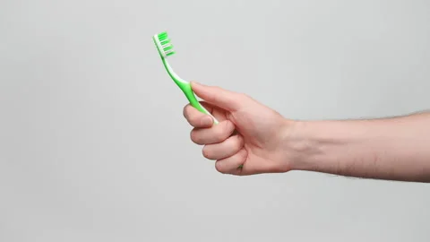Close up shot of a man's hand holding a toothbrush, copy space on the left. 4 Stock Footage 238547891