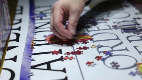 Close-up shot of a mans hand placing jigsaw pieces into place Stock Footage 294151809