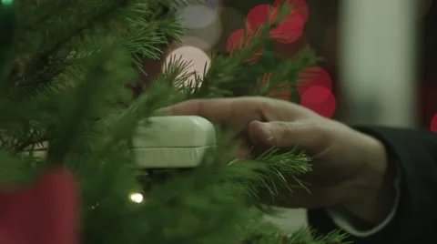 Close up shot of man's hand taking ring box out of Christmas tree and opening it Stock Footage 59457917