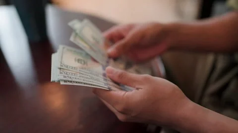 Close-up shot of a man's hands counting money to pay for products to a salespers Stock Footage 265766459