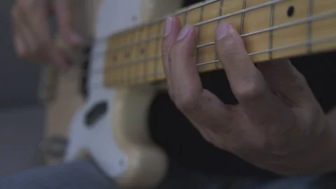 Close-up shot of a man's hands playing an electric guitar bass at home. Stock Footage 127330804