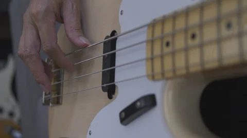 Close-up shot of a man's hands playing an electric guitar bass at home. Stock Footage 127609521
