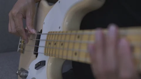 Close-up shot of a man's hands playing an electric guitar bass at home. Stock Footage 128241802