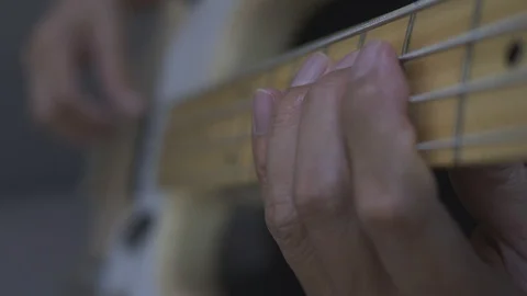 Close-up shot of a man's hands playing an electric guitar bass at home. Stock Footage 128886310