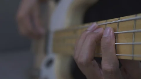 Close-up shot of a man's hands playing an electric guitar bass at home. Stock Footage 128896683