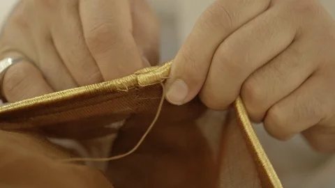 Close up shot on man's hands' sewing to Saudi outfit Stock Footage 113665446