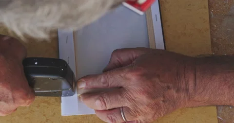 Close up shot of a mans hands stretching and stapling a canvas print on to th Video stock 208057466