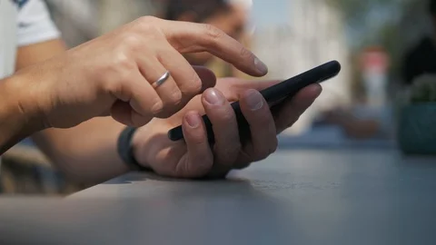 Close - up shot of man's hands use modern mobile phone while sitting at outdoor Stock Footage 106523133