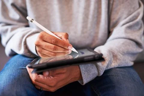 A close up shot of a man's hands using a stylus to draw on a tablet Stock Photos