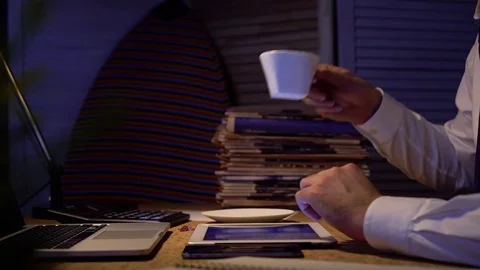 Close up shot of man's hands working with a tablet and drinking coffee Video stock 70240842