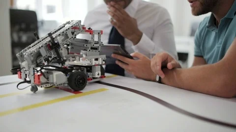 Close up shot of men discussing robotic devise in studio 스톡 동영상 77980723