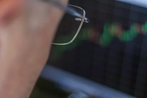 Close up shot of the mid aged man next to the computer screen with trading .. Stockfoto's