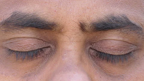 Close shot of a middle aged indian man meditating with eyes closed Stock Footage 148438195