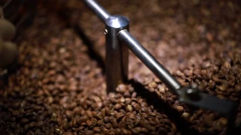 Close-up shot of Mixing dark roasted coffee beans in a cooler Stock Footage 134502576