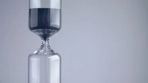 Close up shot of modern design sand clock / hourglass on a grey background. Stock Footage 273115232