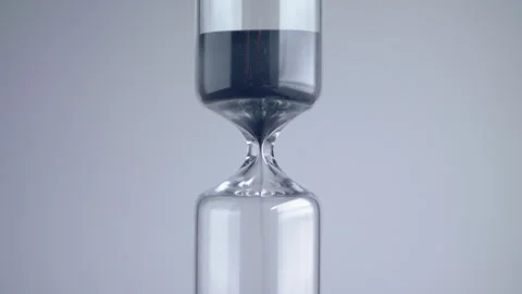 Close up shot of modern design sand clock / hourglass on a grey background. Stock Footage 273115359