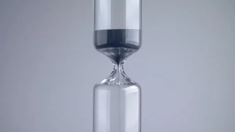 Close up shot of modern design sand clock / hourglass on a grey background. Stock Footage 273115442