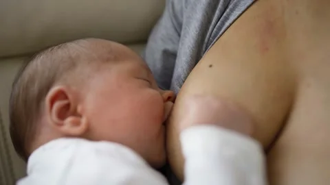 Close Up Shot Of Mother Sitting On Sofa At Home And Breastfeeding Baby Stock-Footage 147582692