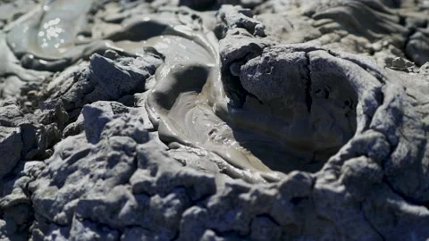 Close up shot of the mud exploding from the earth at the Mud Volcanoes in Stock Footage 134907439