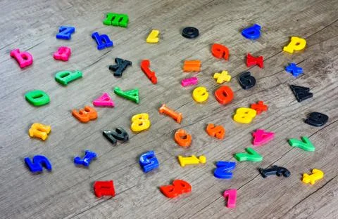 Close up  shot of multi colored  plastic toy  numbers and  letters on  wooden Stock Photos