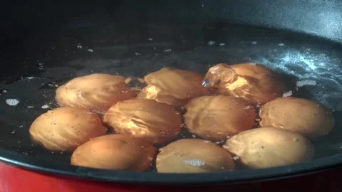 Close-up shot of multiple eggs boiling in a pot of water. 스톡 동영상 348208678