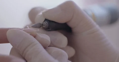 Close-up shot of a nail drill being used by a professional manicurist to Video stock 118973587