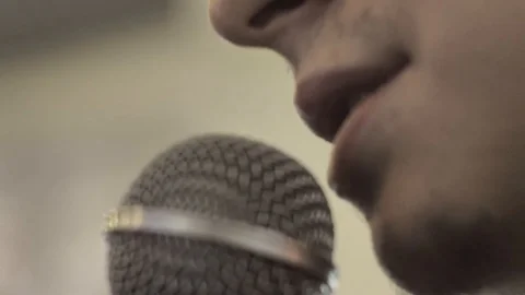 A close shot of narrator/commentator speaking his mind into a mic. Video stock 88533197
