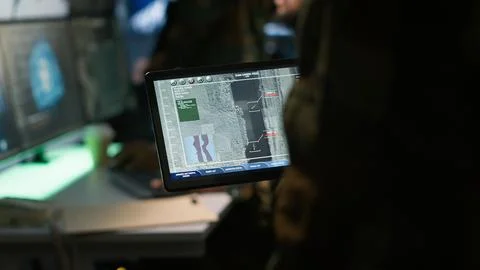 Close up shot of officer using software on device to do assessment of enemy Stock Photos