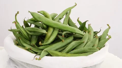 Close shot oif white back filled with green beans Vídeo Stock 159638591