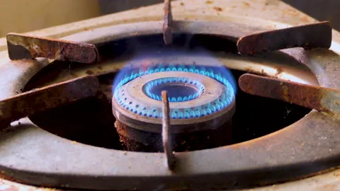 Close shot of an old and dirty gas burner hand turns it on with a matchstick Stock Footage 146803111