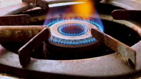 Close shot of an old and dirty gas burner, hand turns on and off the stove Stock Footage 146804249