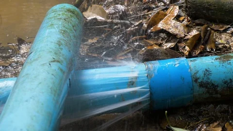 Close up shot of old blue PVC pipes leaking water. PAN RIGHT TO LEFT Stock Footage 97447261