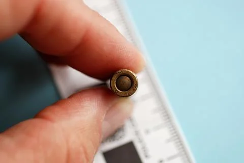 Close up shot on an old unexploded bullet held by a hand, for police ballist Foto stock