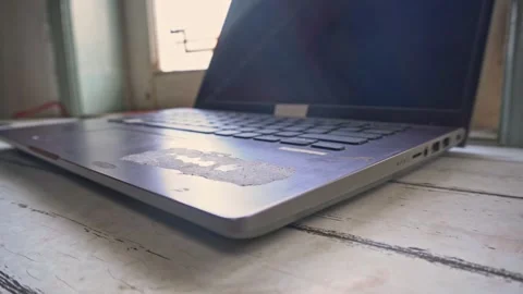 Close up shot of an old worn laptop computer with peeled palm rest on a rus.. Stock Footage 345137927