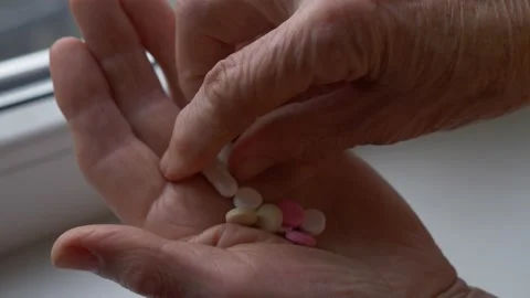 Close up shot of old wrinkled hand taking medicine tablets from the palm. Senior Stock Footage 141146161