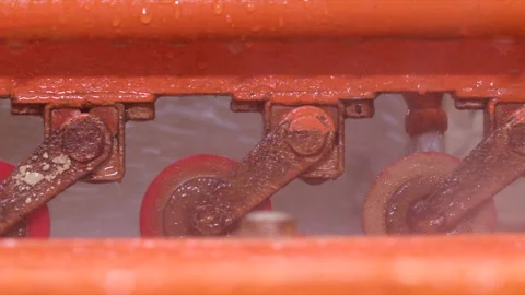Close Shot of Orange Color Machine Splashing Water in a Factory Slow Motion Video stock 166416633