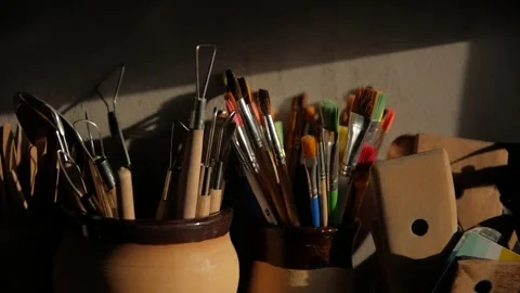A close-up shot of paint brushes and modeling clay tools in ceramic vases. Stock Footage 272224250