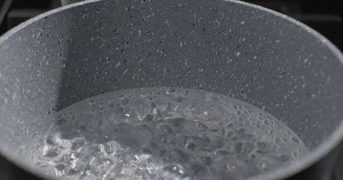 Close-up shot of pan with boiling water on a black background. Boiling water Stock Footage 252611578